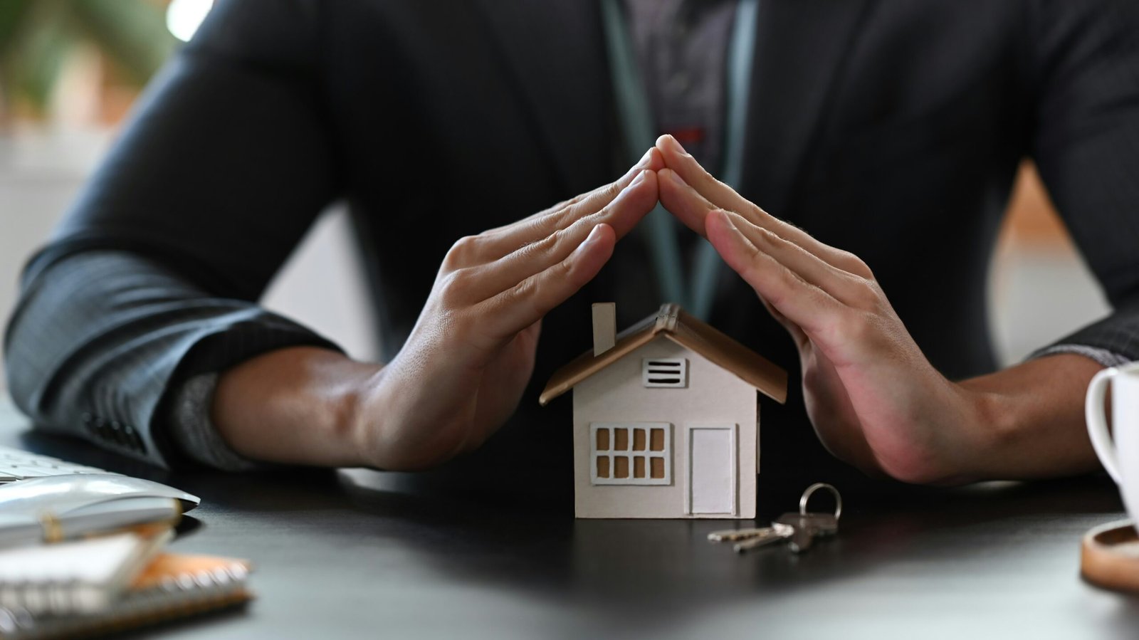 Hands sheltering a home