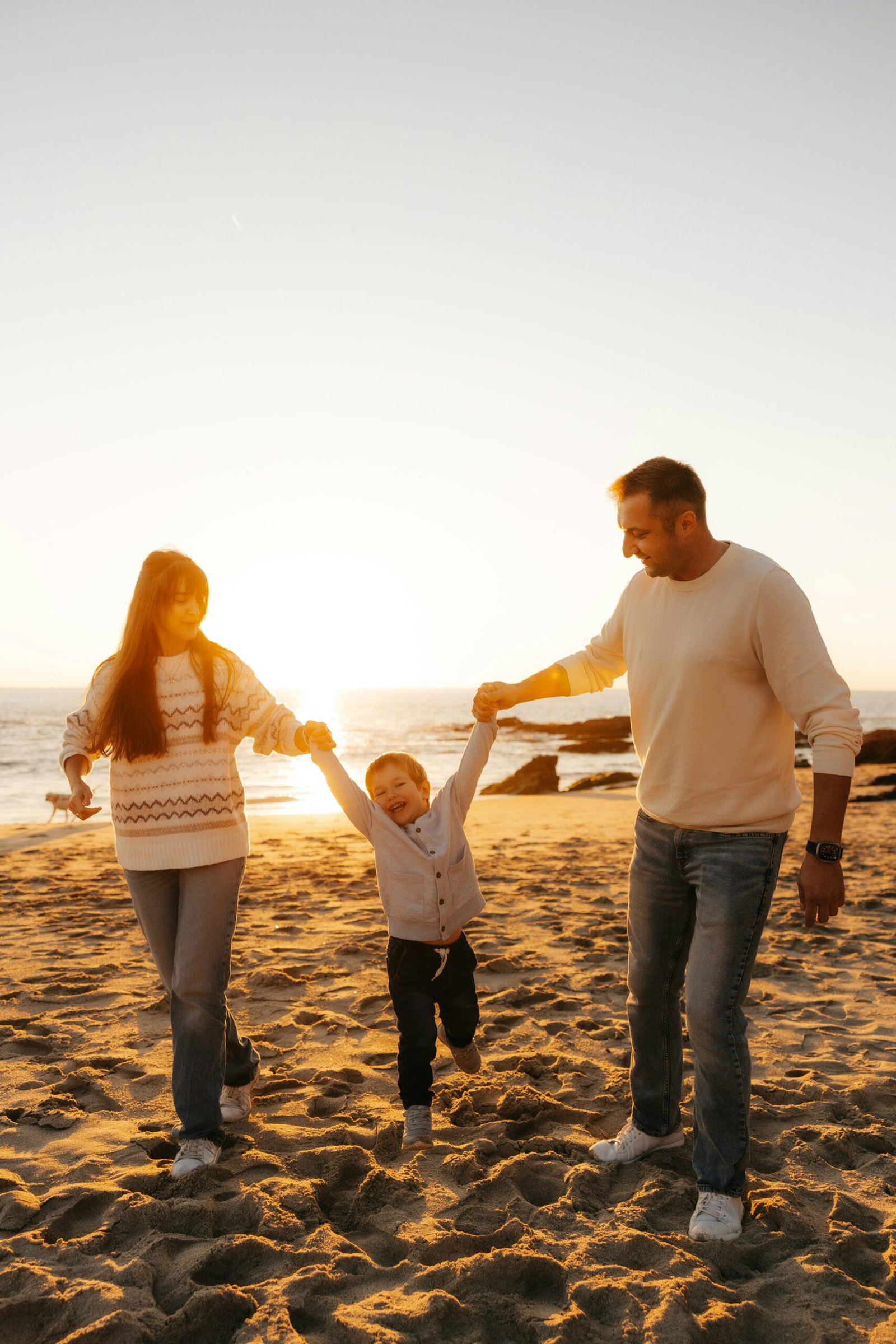 A family walking together on a beach at sunset